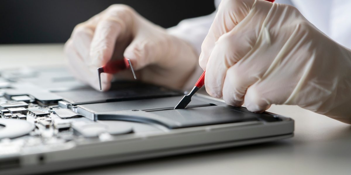 a laptop battery fix, serviceman changing the battery components