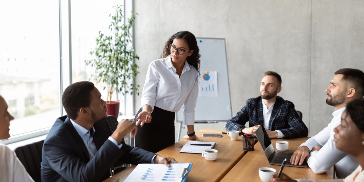 Businesswoman On Business Meeting Talking With Colleagues Standing In Office