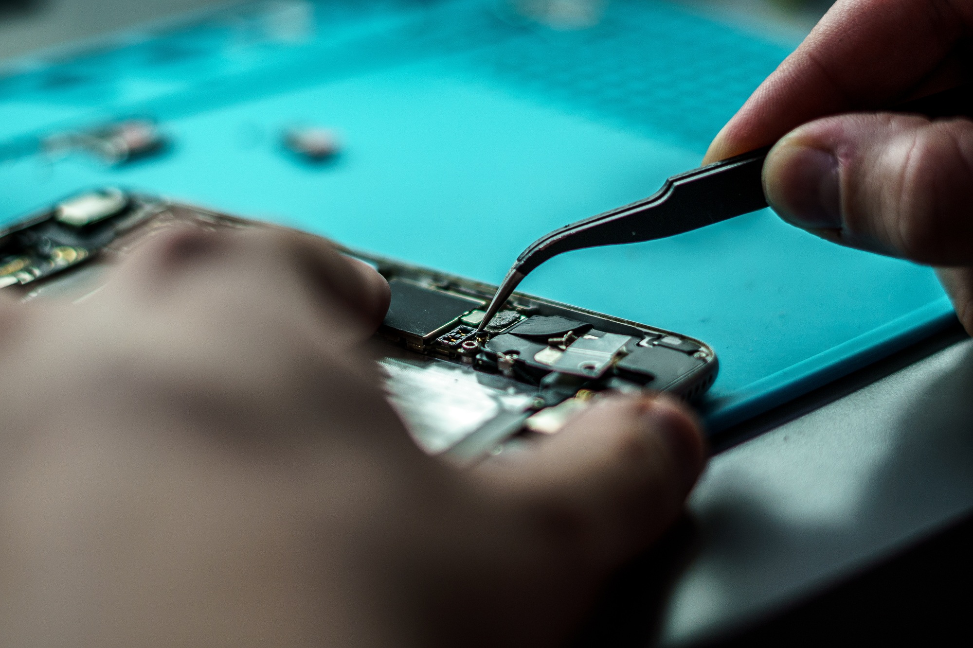 Closeup shot of a person repair a mobile in mobile repair smartphone workshop