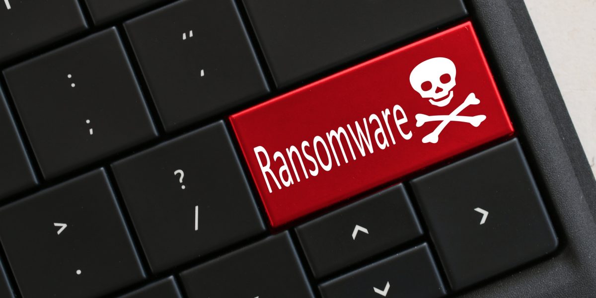 Ransomware concept Computer Keyboard with red RANSOMWARE skull crossbones Hacked virus cyber attack