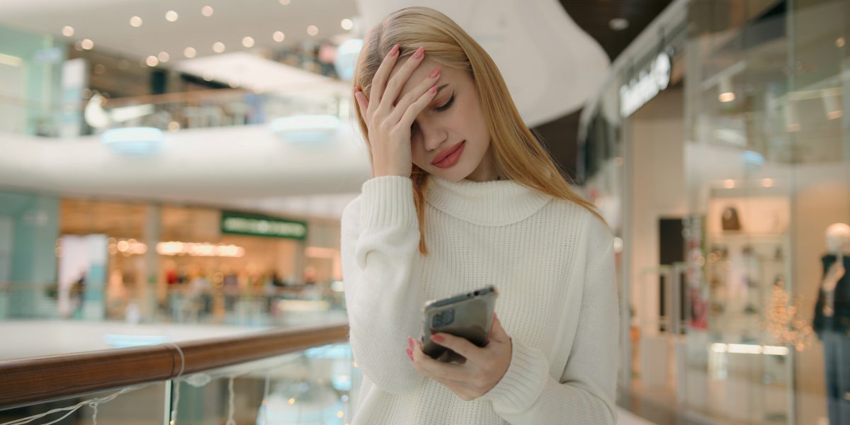 Sad Caucasian puzzled anxious female businesswoman 25s woman has problem with smartphone receive bad