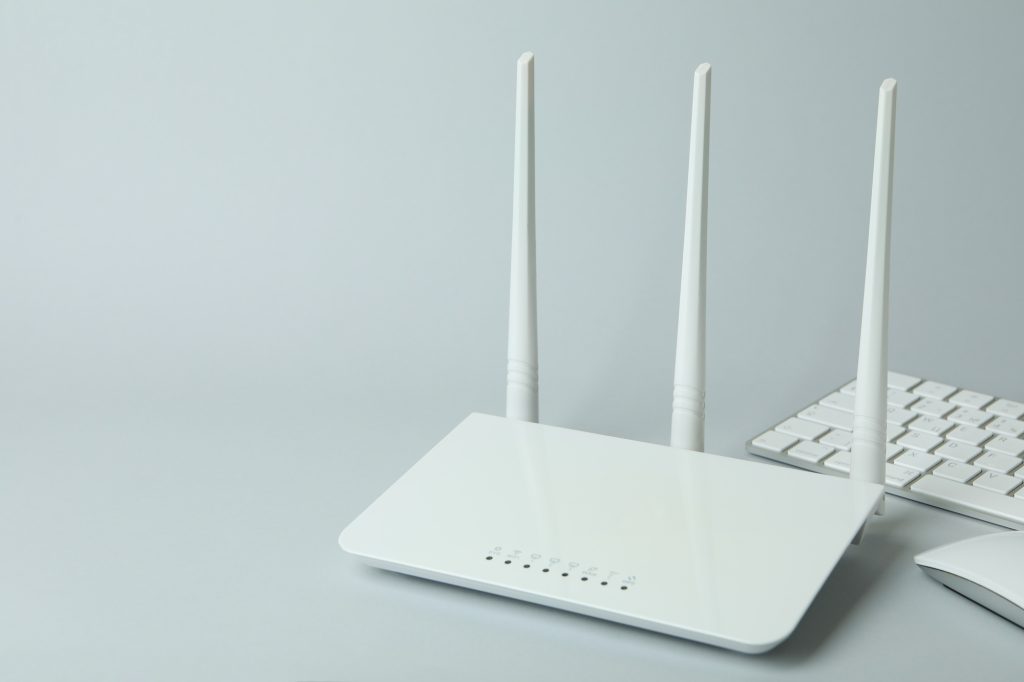 Workplace with Wi - fi router on gray background