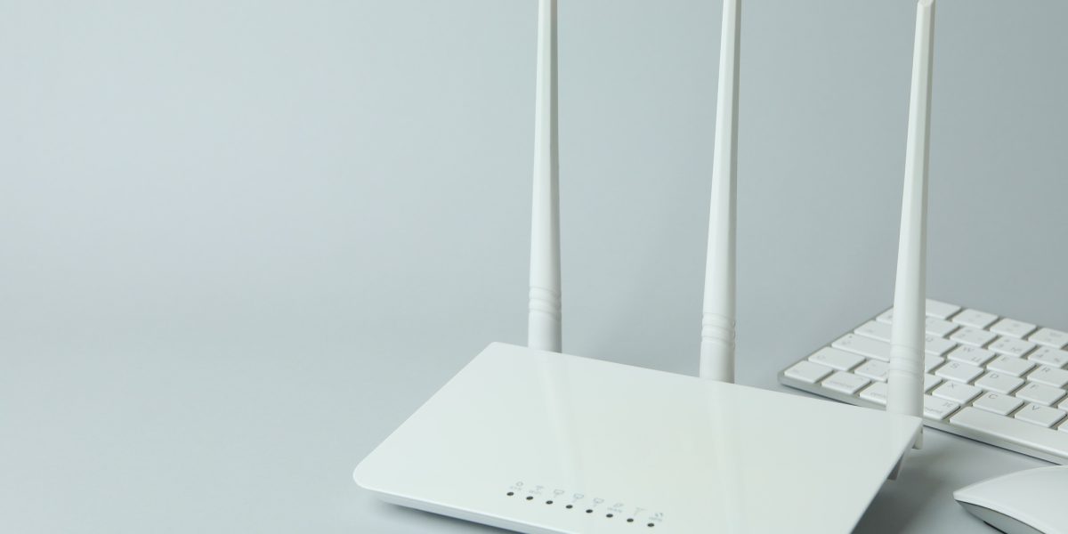 Workplace with Wi - fi router on gray background